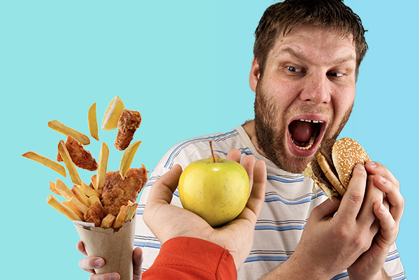 Ein Mann beißt in einen Burger, während er einen Apfel hingehalten bekommt und diesen geschockt anschaut. Eine weitere Hand hält eine Tüte mit Pommes und Hähnchennuggets hoch.